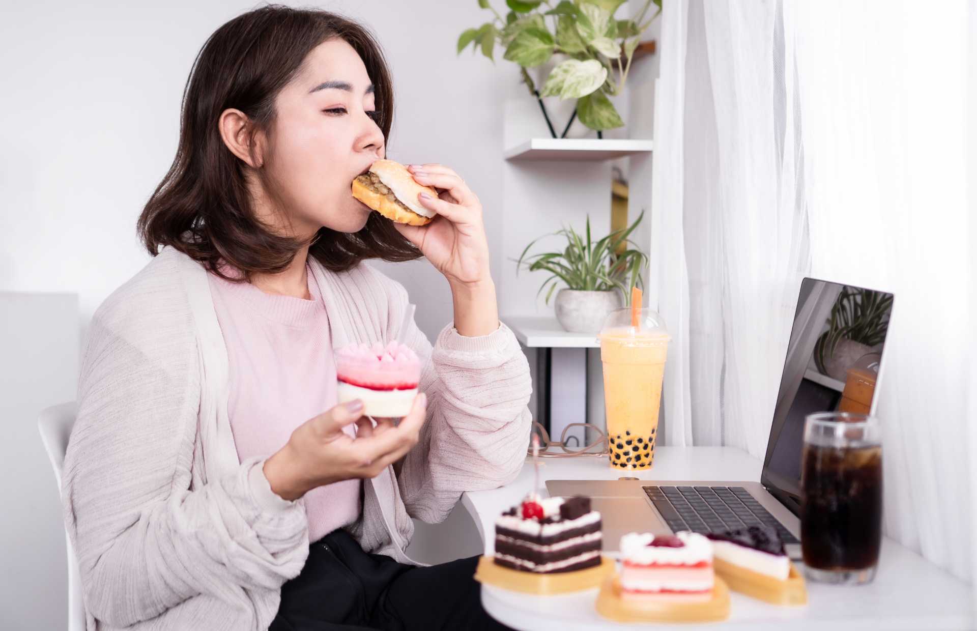 asian woman binge eating cake and other foods